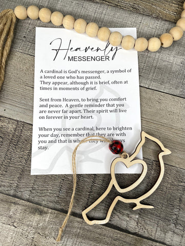 A handcrafted story charm featuring a wooden bird-shaped figure attached to a card with an inspirational message, placed on a wooden surface.