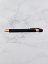 Black pen with rose gold accents on a marble surface