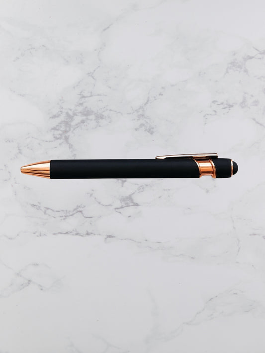 Black pen with rose gold accents on a marble surface
