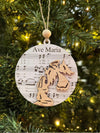 Decorative Christmas ornament with 'Ave Maria' text and music notes on a tree.