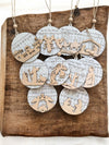 Set of Christmas ornaments with nativity scenes and lyrics on a wooden surface