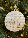 Decorative Christmas ornament with musical notes and a wooden design on a tree.