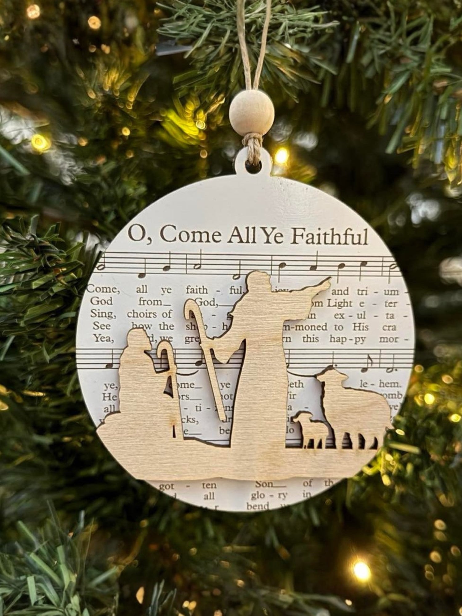 Decorative Christmas ornament with musical notes and a wooden design on a tree.