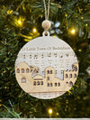 Decorative Christmas ornament with a town design on a tree.