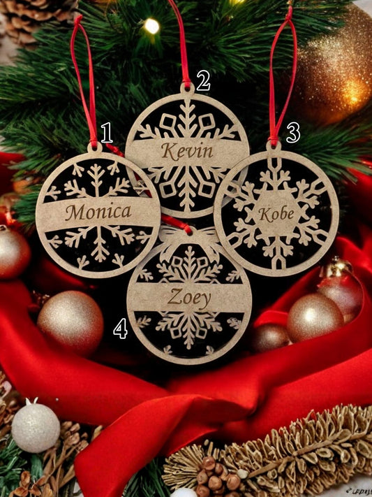 Wooden Christmas ornaments with names engraved, placed on a festive background with red ribbon and gold ornaments.