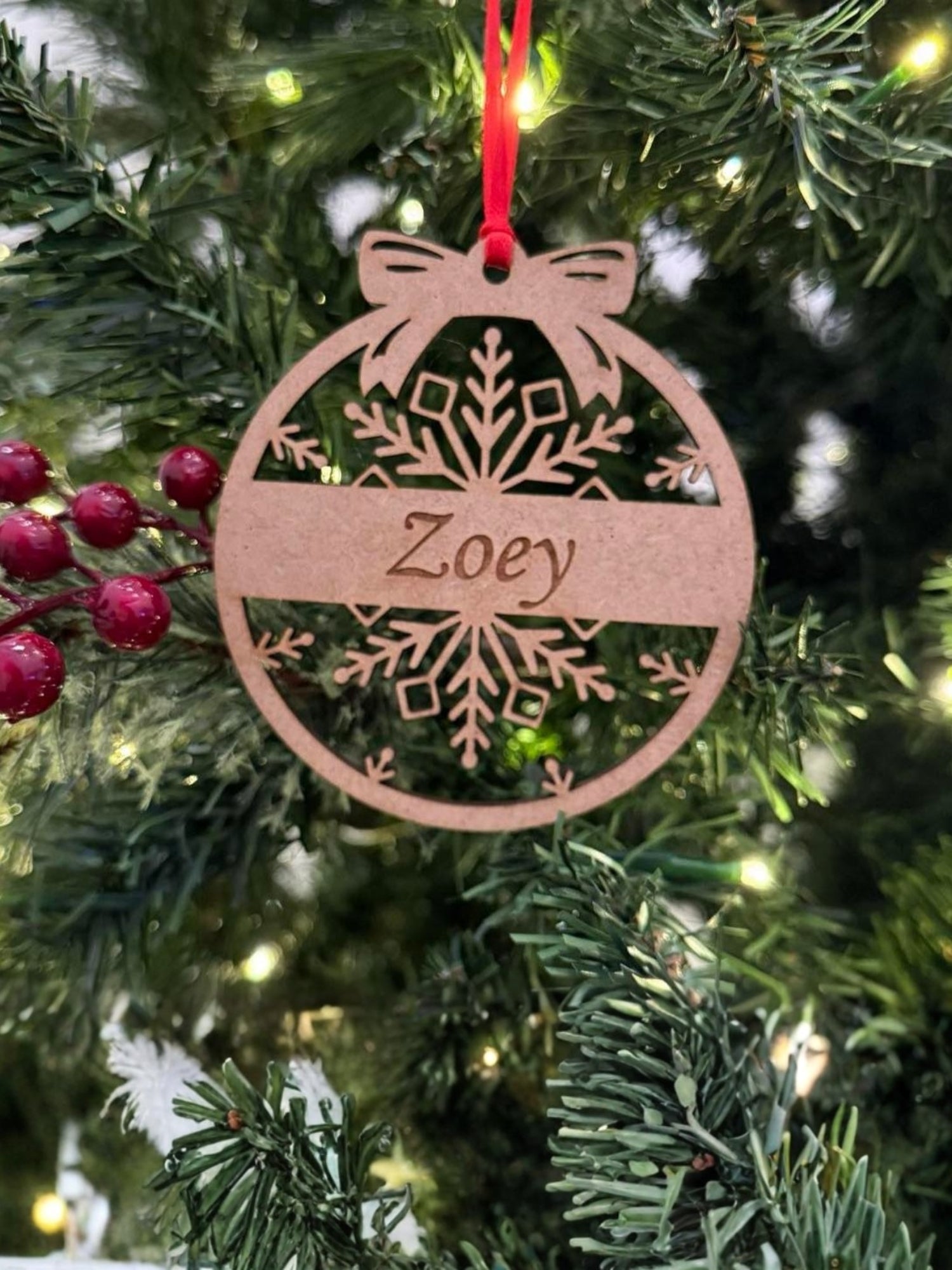 Decorative Christmas ornament with 'Zoey' on a tree