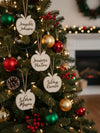 Decorated Christmas tree with personalized name tags and colorful ornaments.